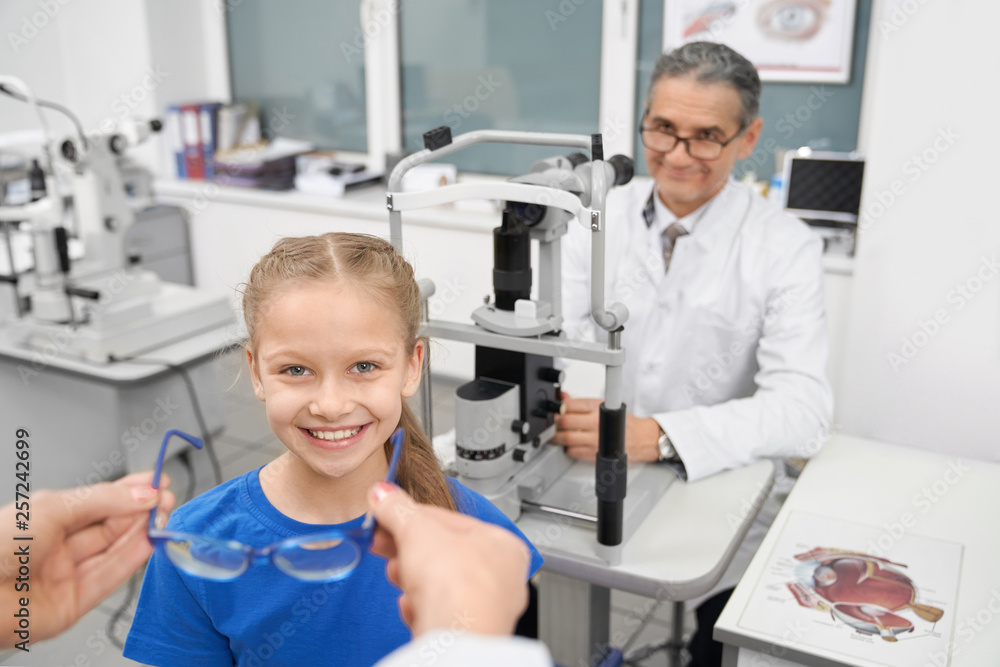 Hands of doctor giving glasses to little patient. Hands of doctor giving glasses to little patient.
