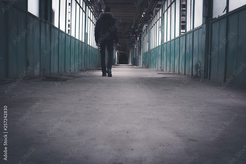 Man going to the end of the tunnel in the dark. The concept of movement into an unknown future Man going to the end of the tunnel in the dark. The concept of movement into an unknown future