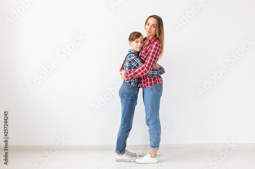 Mothers day, children and family concept - teen boy hugging his mom on white background with copy space