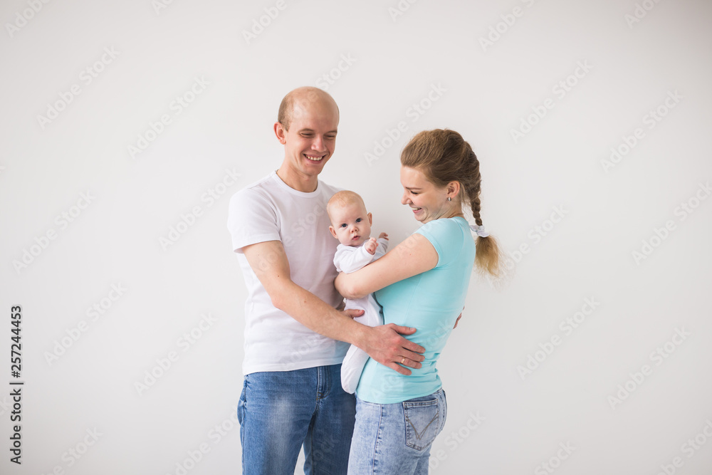 Parenthood, love and family concept - Smiling mother and father holding their baby daughter Parenthood, love and family concept - Smiling mother and father holding their baby daughter