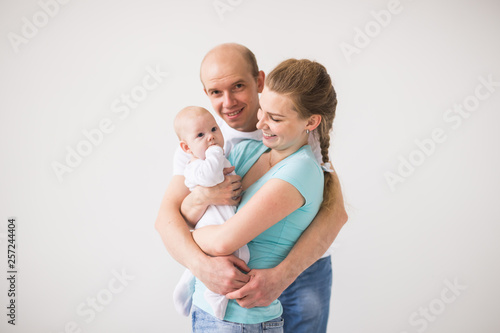 Family, parent and children concept - Portrait of a happy family with their baby daughter on white background with copy space