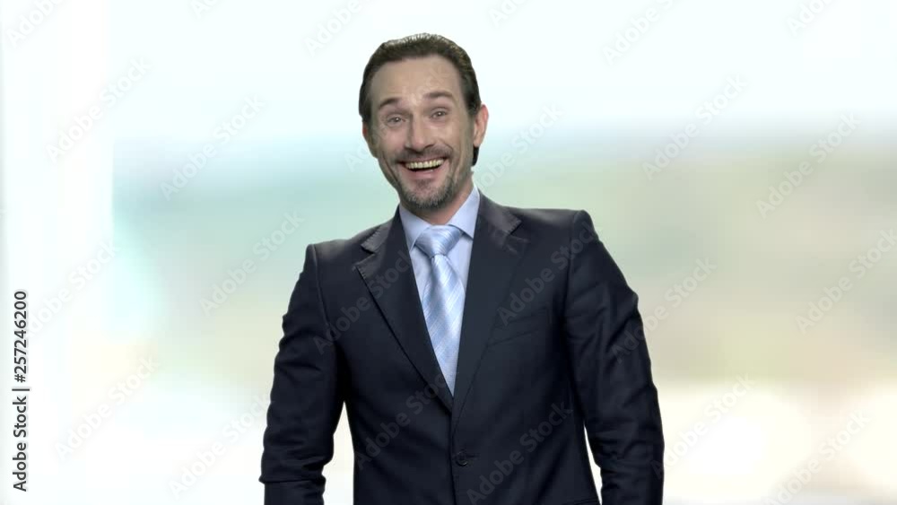 Portrait of joyful laughing businessman. Attractive caucasian man in elegant suit is laughing on blurred background. Human expression of joy. Portrait of joyful laughing businessman. Attractive caucasian man in elegant suit is laughing on blurred background. Human expression of joy.