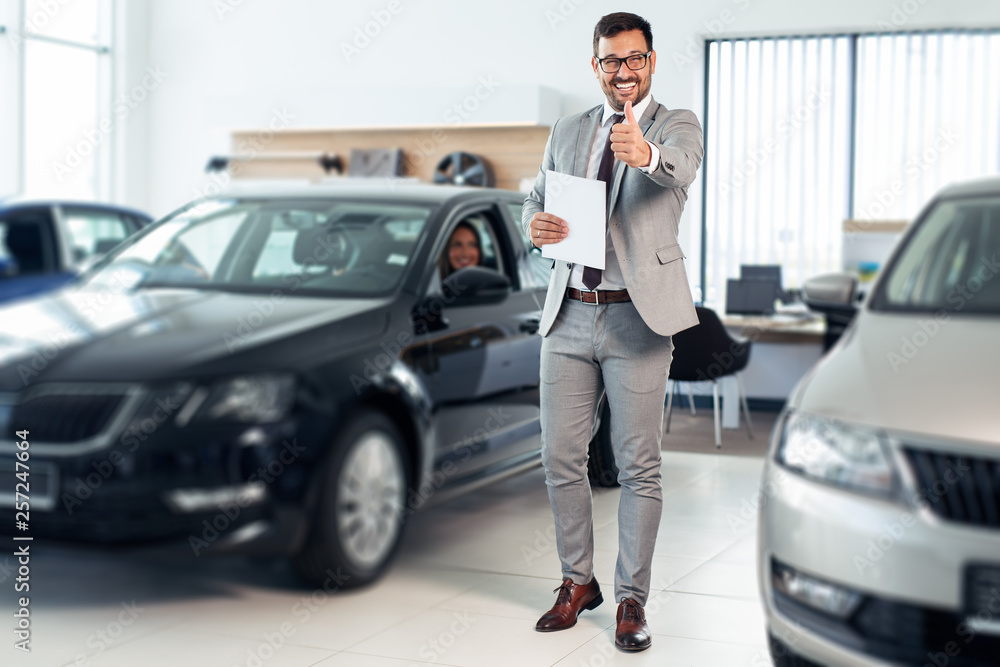 Successful young male working in car dealership Successful young male working in car dealership