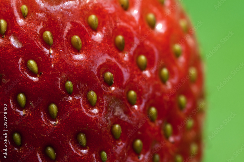 Macro of red strawberry on a green background Macro of red strawberry on a green background