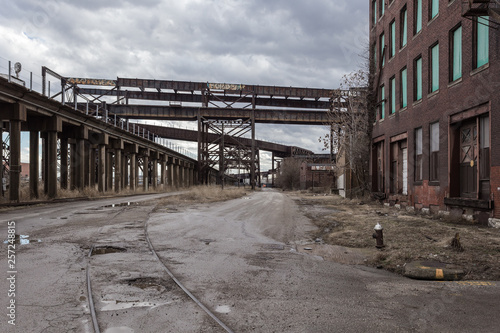 Crossing elevated train tracks and vintage red brick abandoned factory