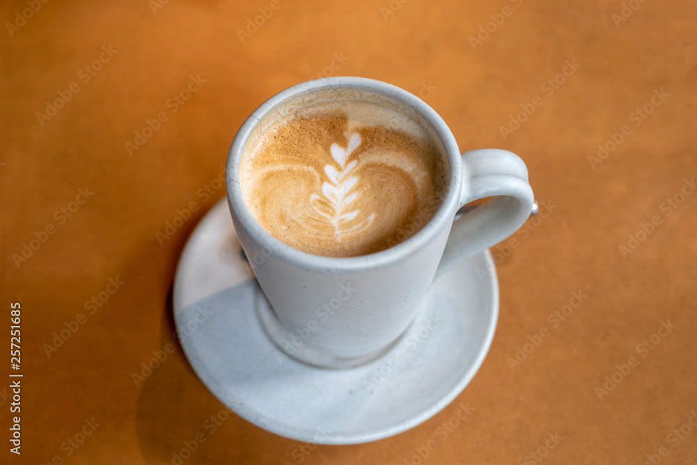 Cup of beautiful Latte art coffee on the wooden table in coffee shop, Top view of hot coffee cappucino cup. Cup of beautiful Latte art coffee on the wooden table in coffee shop, Top view of hot coffee cappucino cup.