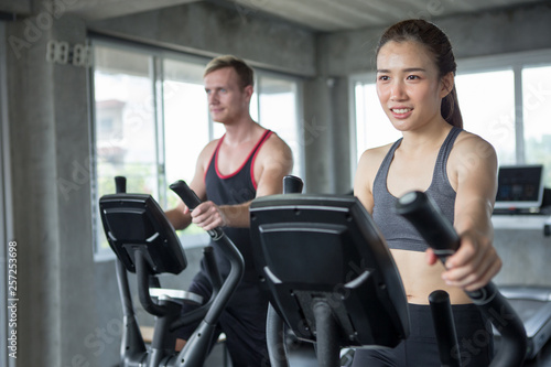 Young couple sport exercise with elliptical machine in gym . fitness man and woman workout together ,training, © iammotos