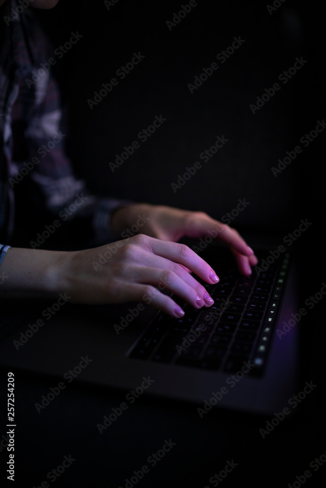 Hands with laptop in night pressing button Hands with laptop in night pressing button