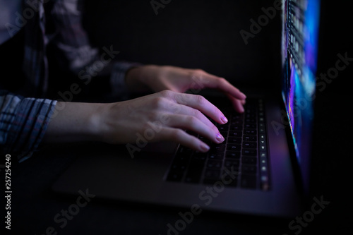 Hands with laptop in night pressing button