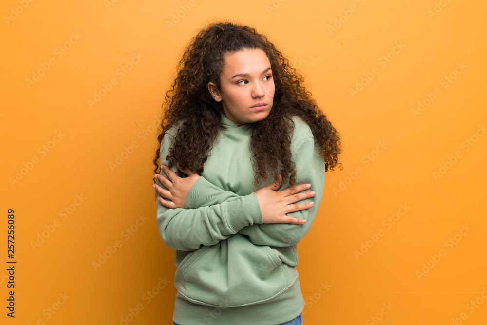 Teenager girl over ocher wall freezing Teenager girl over ocher wall freezing