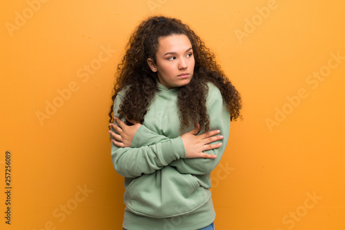 Teenager girl over ocher wall freezing © luismolinero