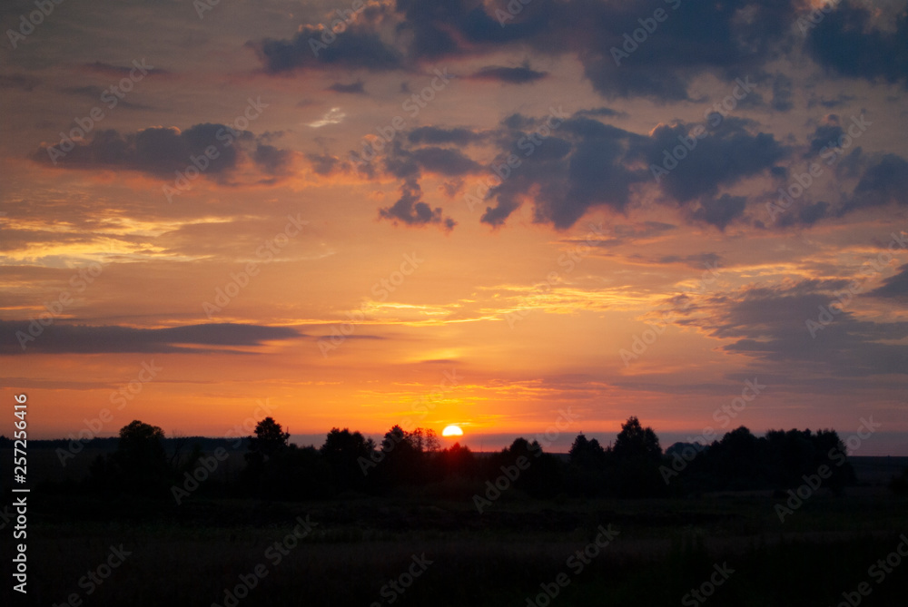 View of a Beautiful Sunset and Sky with dramatic clouds over a Silhouetted Land Horizont. View of a Beautiful Sunset and Sky with dramatic clouds over a Silhouetted Land Horizont.