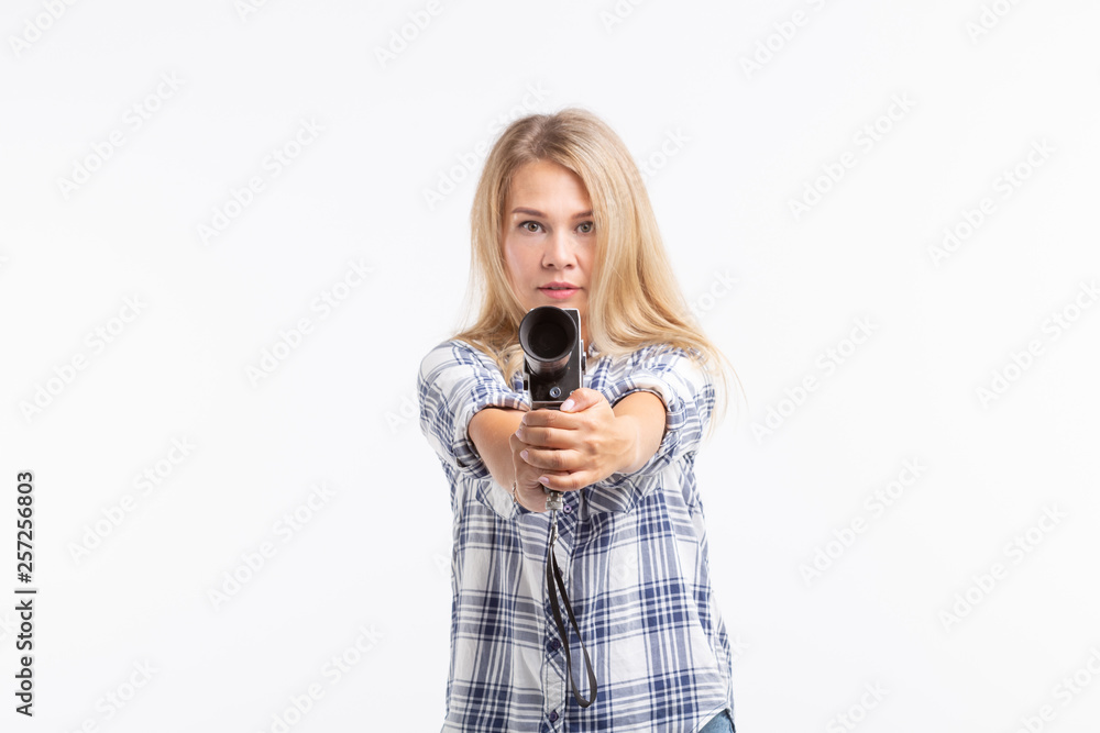 Joke, photographing and humor concept - blonde young woman with retro camera like a gun over white background Joke, photographing and humor concept - blonde young woman with retro camera like a gun over white background