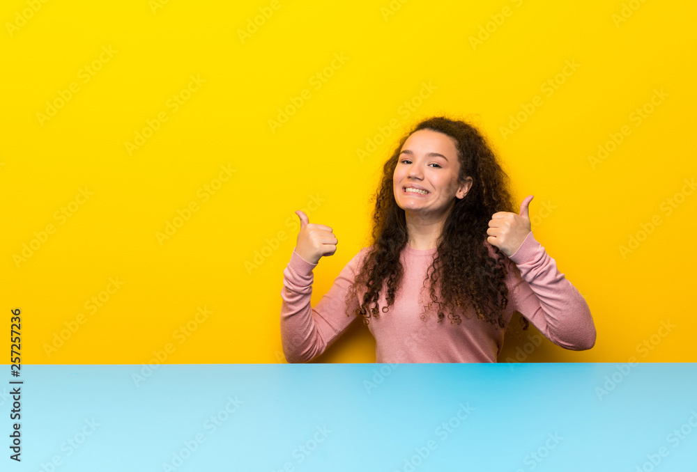 Teenager girl with thumbs up gesture and smiling Teenager girl with thumbs up gesture and smiling