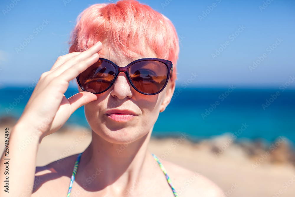 Young female model with pink hair and sunglasses on the beach Young female model with pink hair and sunglasses on the beach