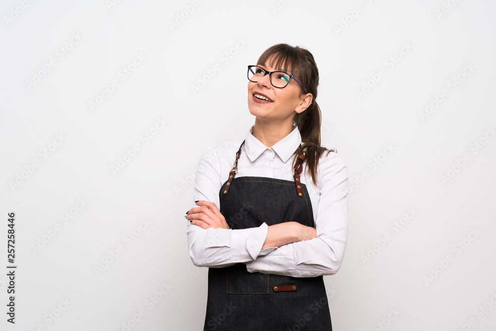 Young woman with apron looking up while smiling Young woman with apron looking up while smiling