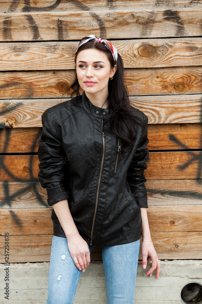 fashion model in black leather jacket posing outdoor. outdoor portrait of young european beautiful stylish girl 