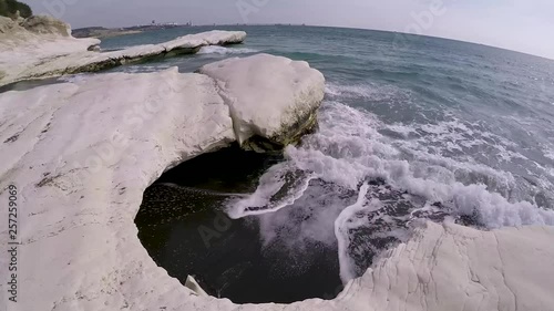 Wide angel view of white chalk cliffs and waves of Mediterranean sea on famous Cyprus landmark Governors black sand beach. photo