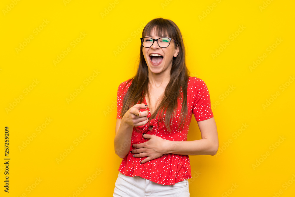 Young woman over yellow wall smiling a lot Young woman over yellow wall smiling a lot