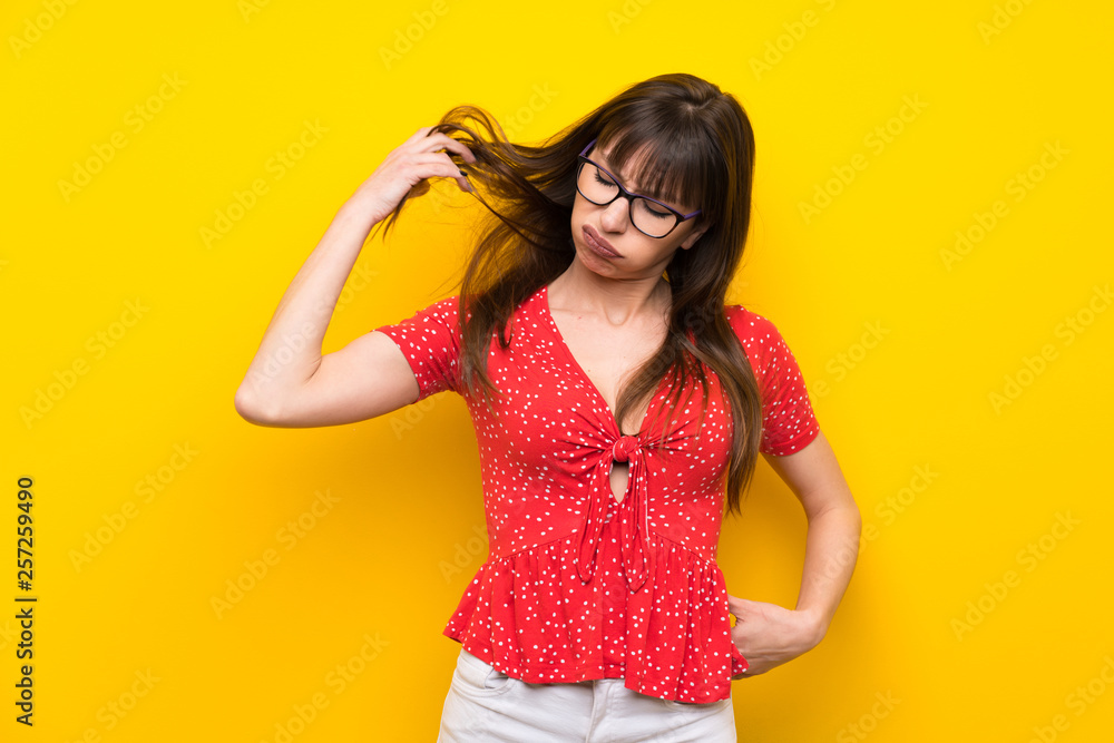 Young woman over yellow wall with tired and sick expression Young woman over yellow wall with tired and sick expression