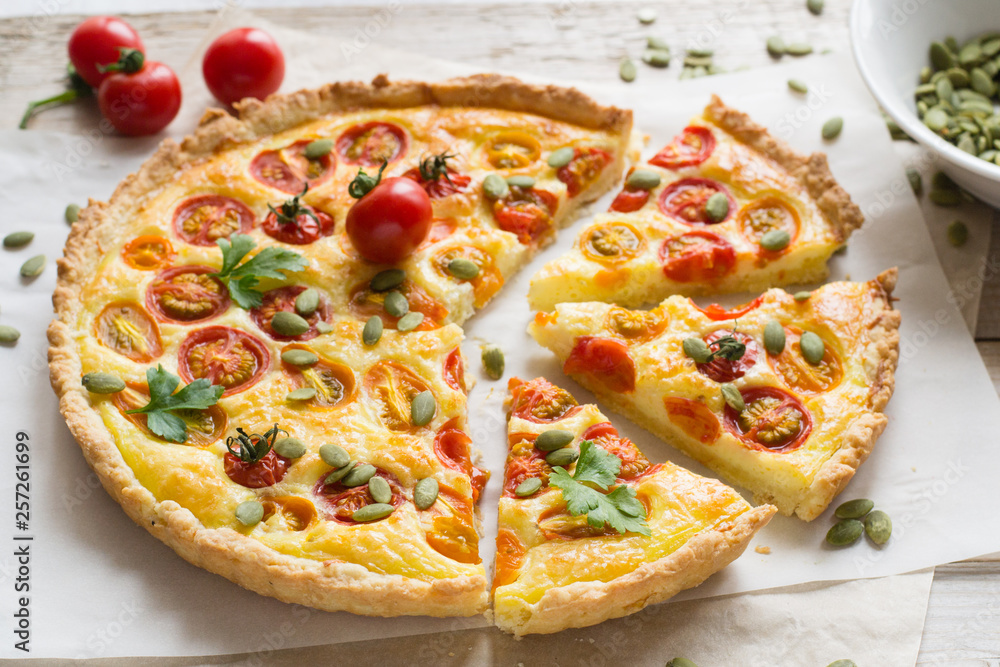 Tomato tart with pumpkin seeds on wooden table Tomato tart with pumpkin seeds on wooden table