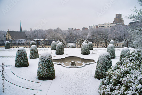 BRUSSELS, BELGIUM - JANUARY 30, 2019: Garden of Cumbre Abbey (Jardins de l'Abbaye de la Cambre). Park in the style of French classicism with green alleys and terraces, fallen snow photo