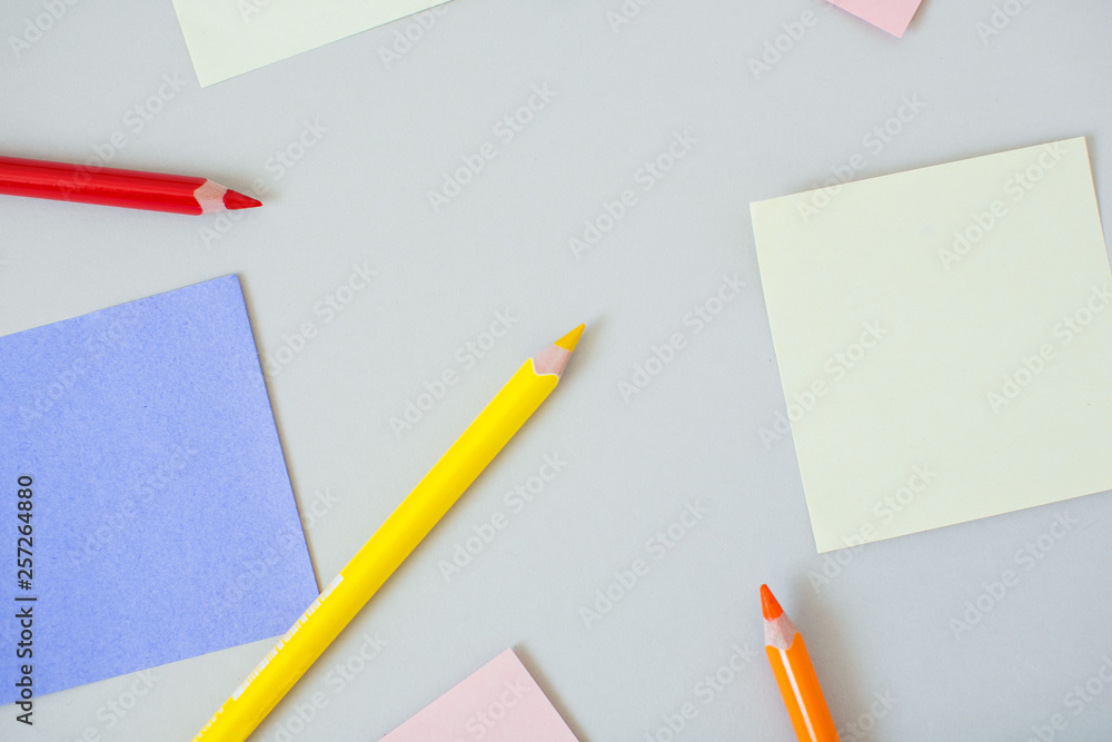Color note papers with pencils on grey background. Color note papers with pencils on grey background.