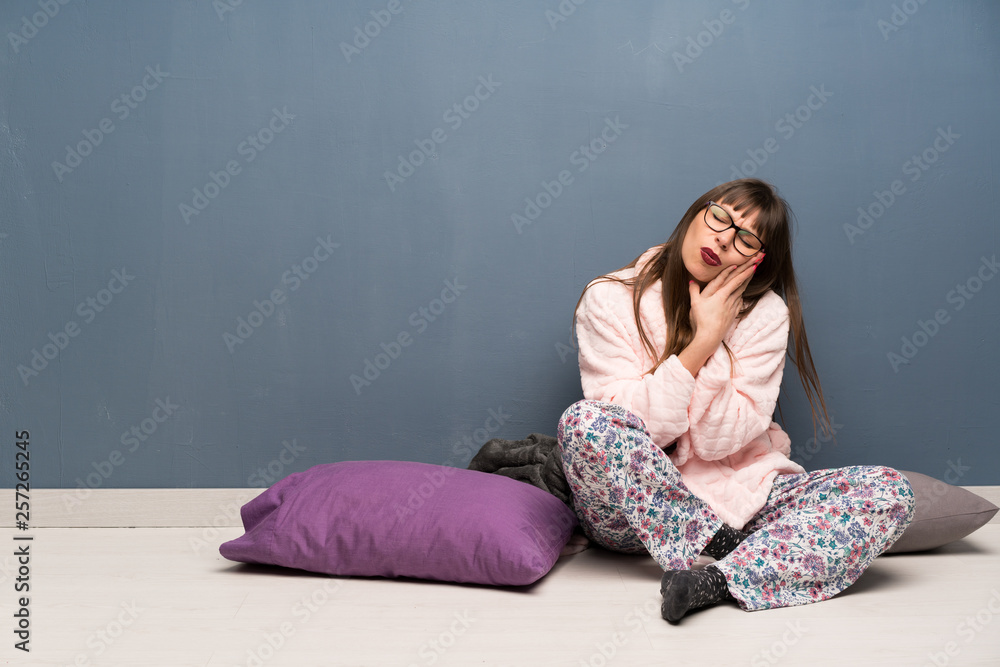 Woman in pajamas on the floor with toothache Woman in pajamas on the floor with toothache
