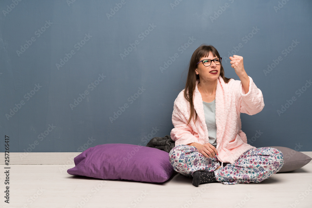 Woman in pajamas on the floor with angry gesture Woman in pajamas on the floor with angry gesture
