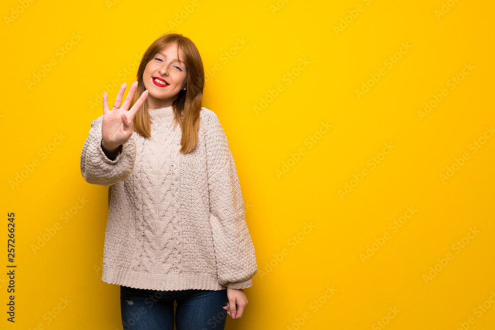 Redhead woman over yellow wall happy and counting four with fingers Redhead woman over yellow wall happy and counting four with fingers