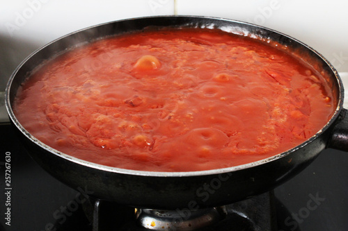red tomato sauce cooking on fire in a pan