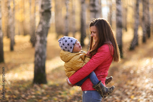 mother holds in arms crying son,hysterics, autumn