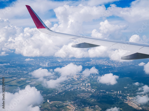 View from airplane window: wing  plane in cloudy sky. photo