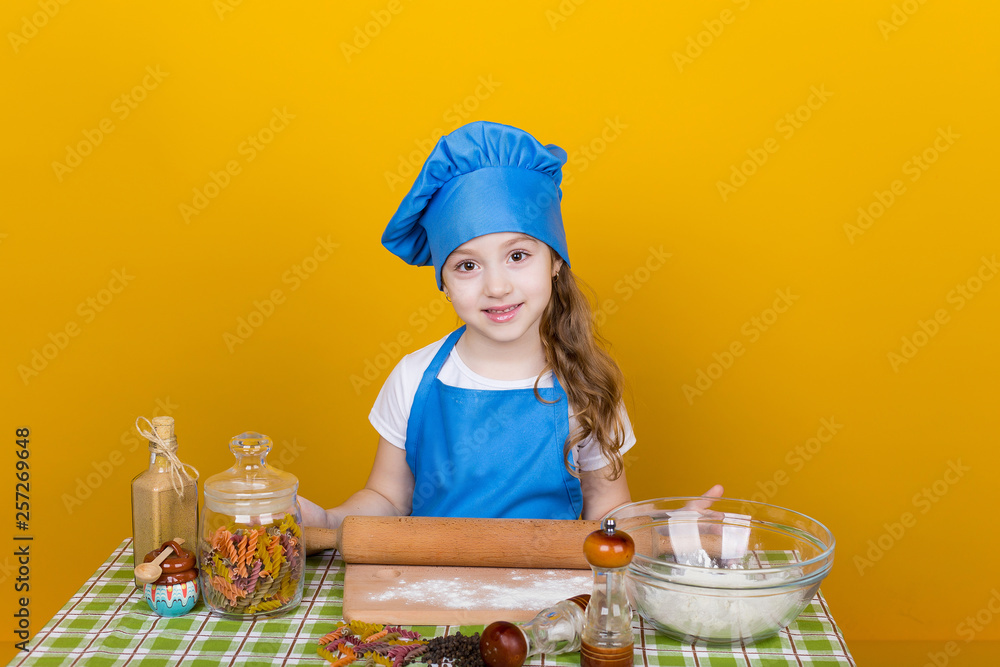 Little baker. Pretty cook kneads dough Little baker. Pretty cook kneads dough
