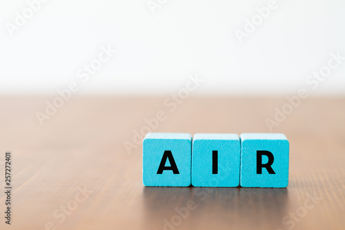 Blue wooden cubes with the lettering "air" on a wooden table