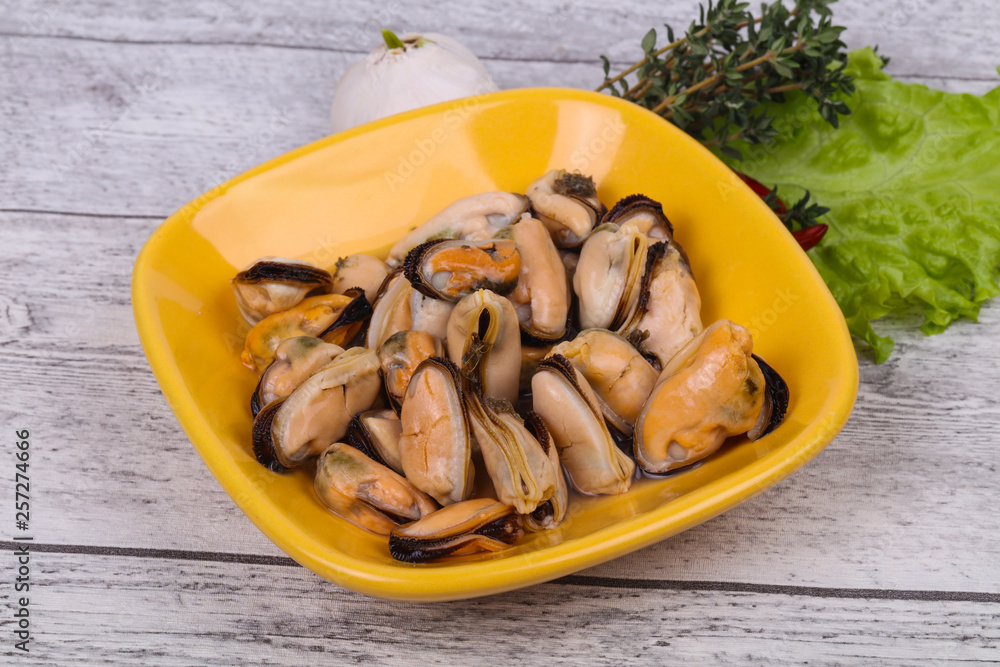 Pickled mussels in the bowl served pepper, garlic and salad Pickled mussels in the bowl served pepper, garlic and salad