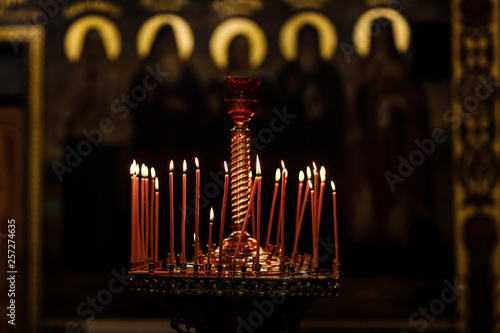 On a large Church copper candlestick lit a small candle. Orthodox Christian Church. Religion