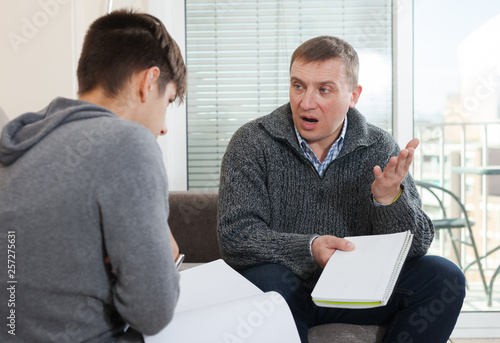 Fotografie Father scolding son for poor school assignment