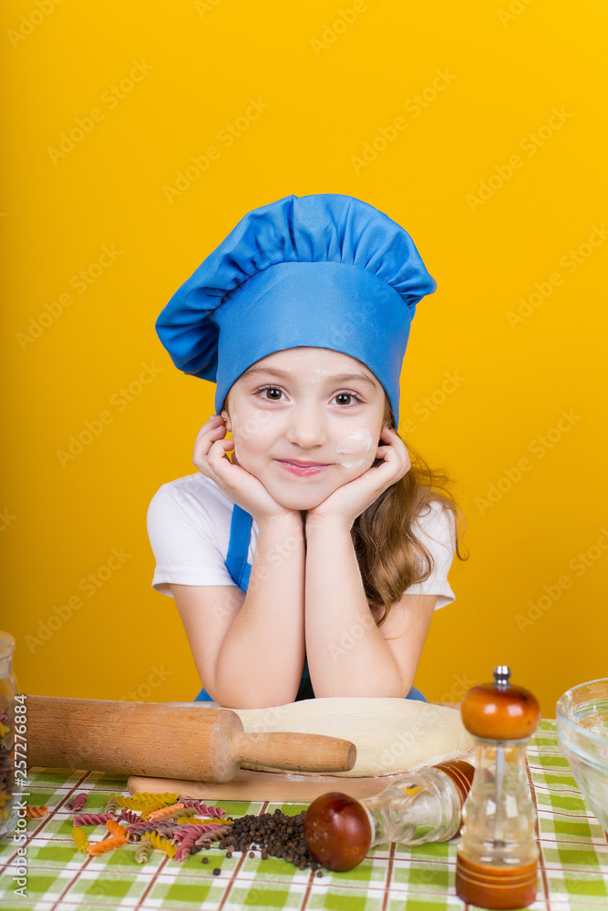 Little baker. Pretty cook kneads dough Little baker. Pretty cook kneads dough