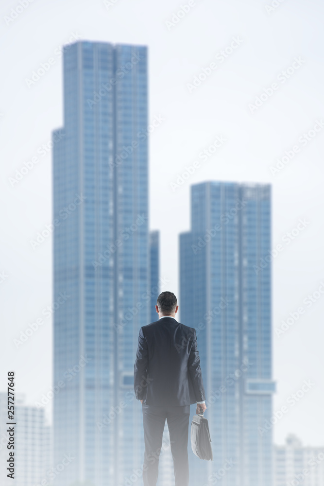 Back view of businessman looking on skyscraper. Back view of businessman looking on skyscraper.