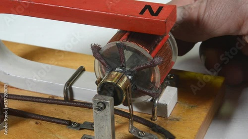 Demonstration model of electric D.C.motor with pemanent magnetic excitation being turned slowly by hand.