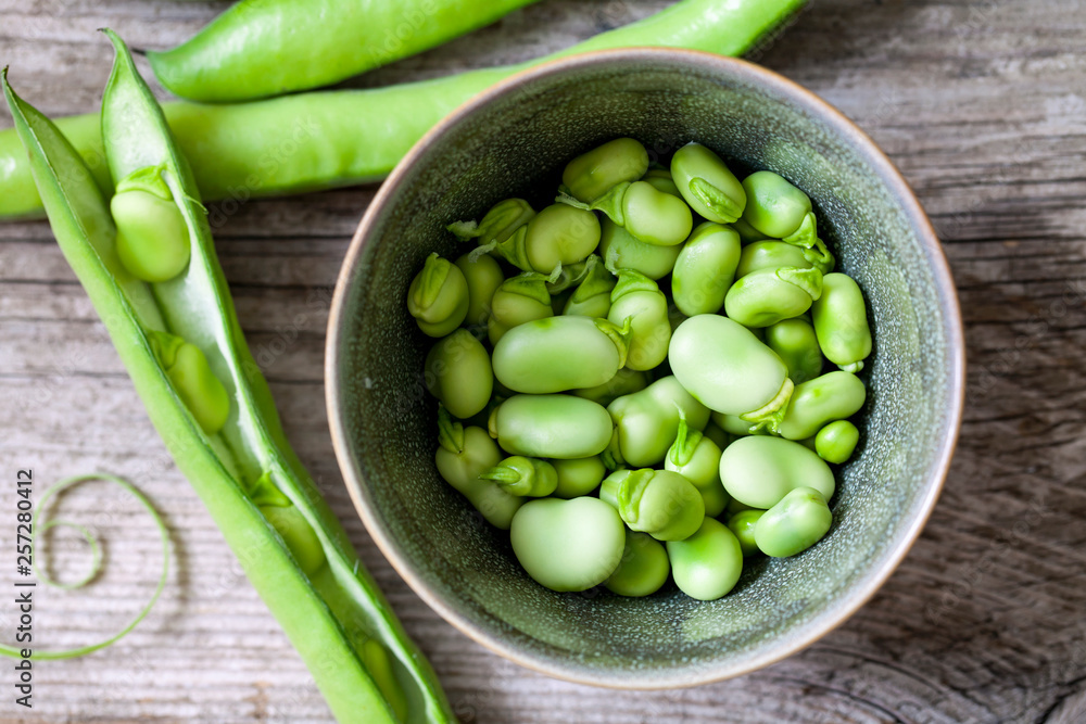 Fresh broad beans on the wooden board Fresh broad beans on the wooden board