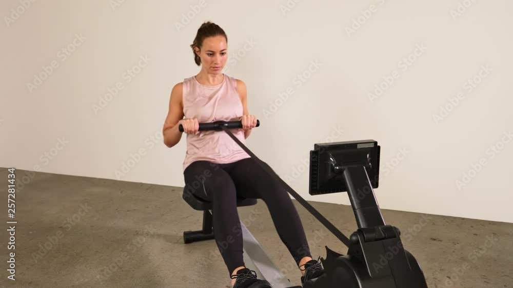 Fit woman exercising on rowing machine Fit woman exercising on rowing machine