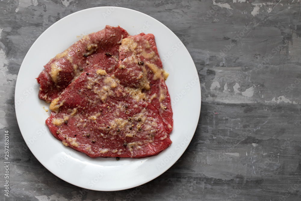 raw meat with spices on white dish