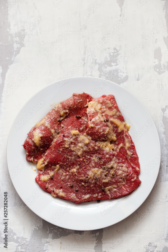 raw meat with spices on white dish raw meat with spices on white dish