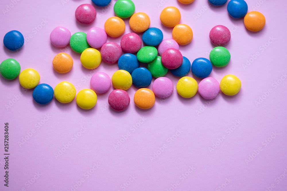 close up of chocolate egg and candy drops on pink background close up of chocolate egg and candy drops on pink background