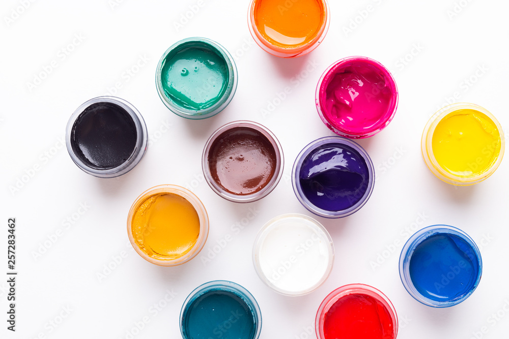 Multicolored gouache on a white background Isolated Paints in containers Top view Multicolored gouache on a white background Isolated Paints in containers Top view