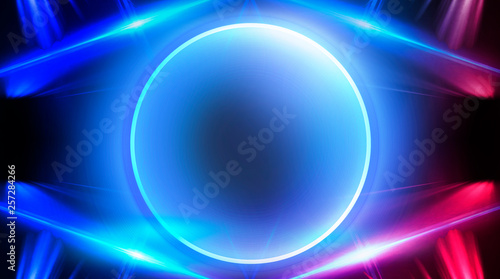 Neon circle, neon lights. Neon circle with the center of a dark empty scene with spotlights. Abstract light. Night view.