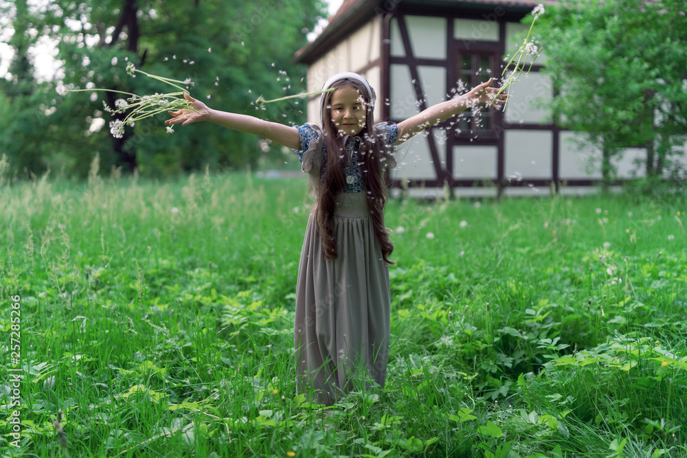 The girl in a dress in retro style throws dandelions. The girl in a dress in retro style throws dandelions.