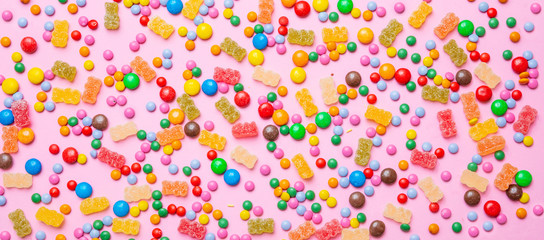 Birthday concept. Colorful sweet candies on pink background